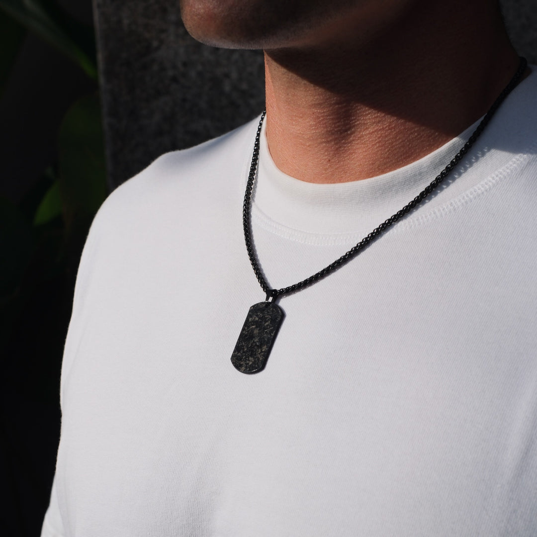 Mann trägt die schwarze Forged Dogtag Chain mit Carbon-Anhänger auf der Brust